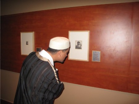 A visitor inspecting the cover image for the show, Rembrandt's self-portrait as an Oriental ruler.